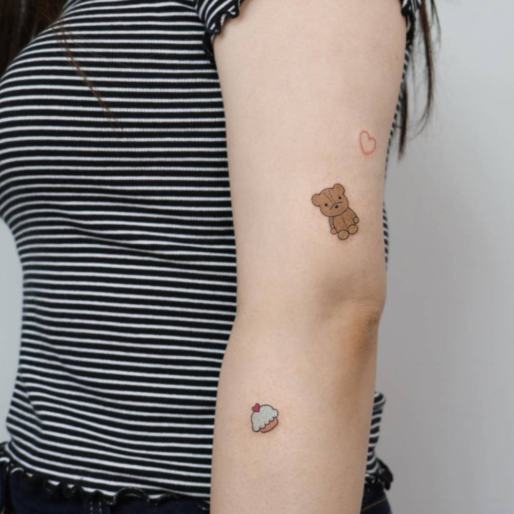 Teddy bear and cupcake tattoos done on the arm.