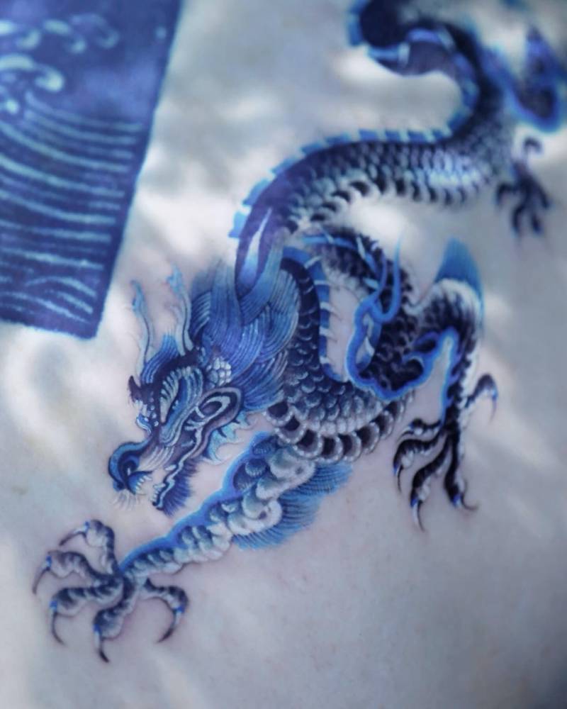 Dragon tattoo in oriental style located on the shoulder blade.