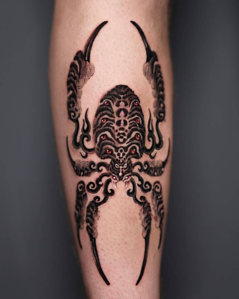 Oriental style spider tattooed on the shin.