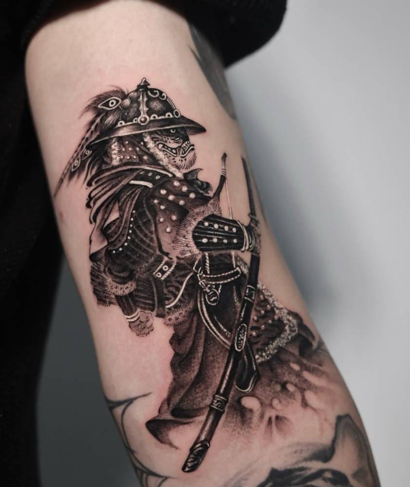 Samurai tattoo in oriental style located on the bicep.