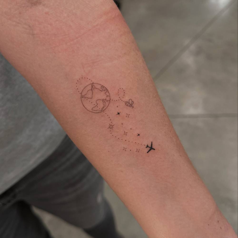 Around the world tattoo in fine line style placed on the inner forearm.