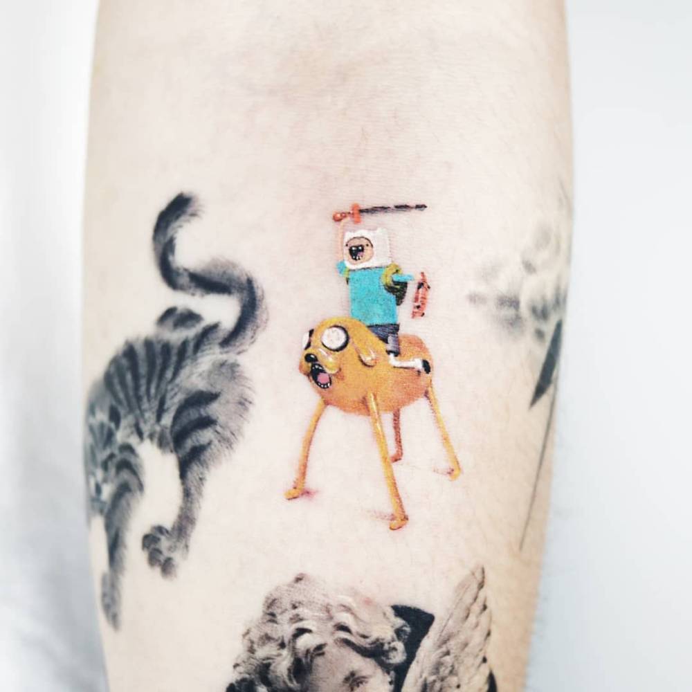 Adventure Time tattoo located on the inner forearm.