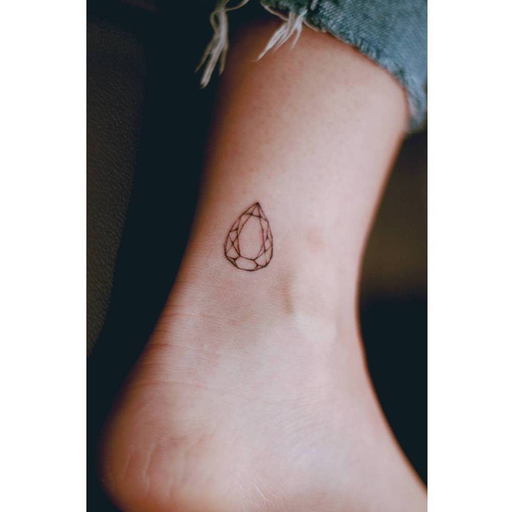 Gem tattoo in fine line style placed on the ankle.