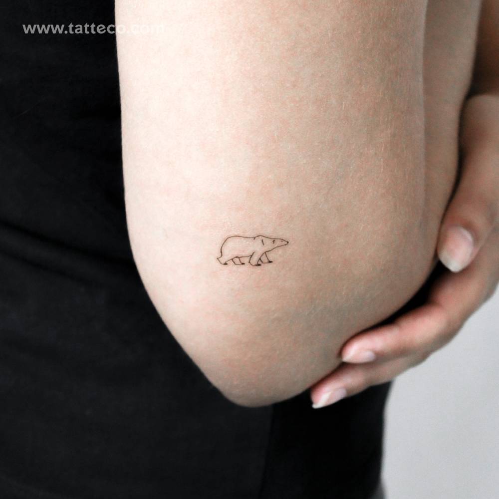 Tiny fine line style polar bear temporary tattoo located on the tricep.