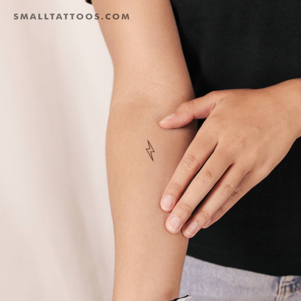 Lightning bolt outline temporary tattoo located on the inner forearm.