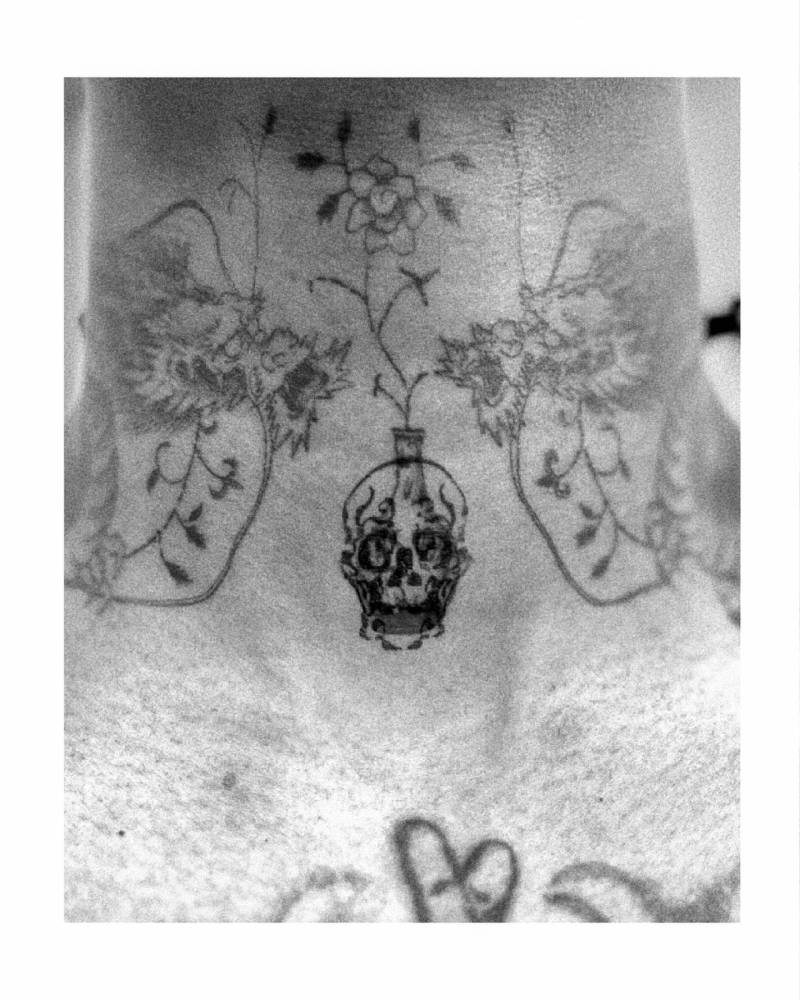 Skull cover up tattoo located on the throat.