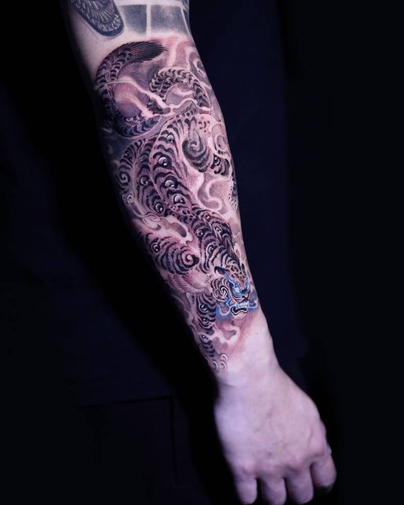Tiger tattoo placed on the forearm, done in oriental style.