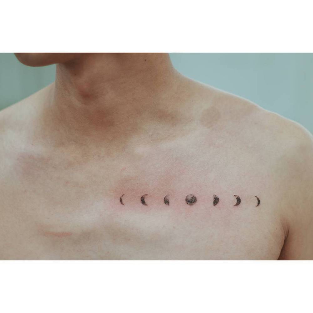 Moon phases tattoo in illustrative style located on the chest.