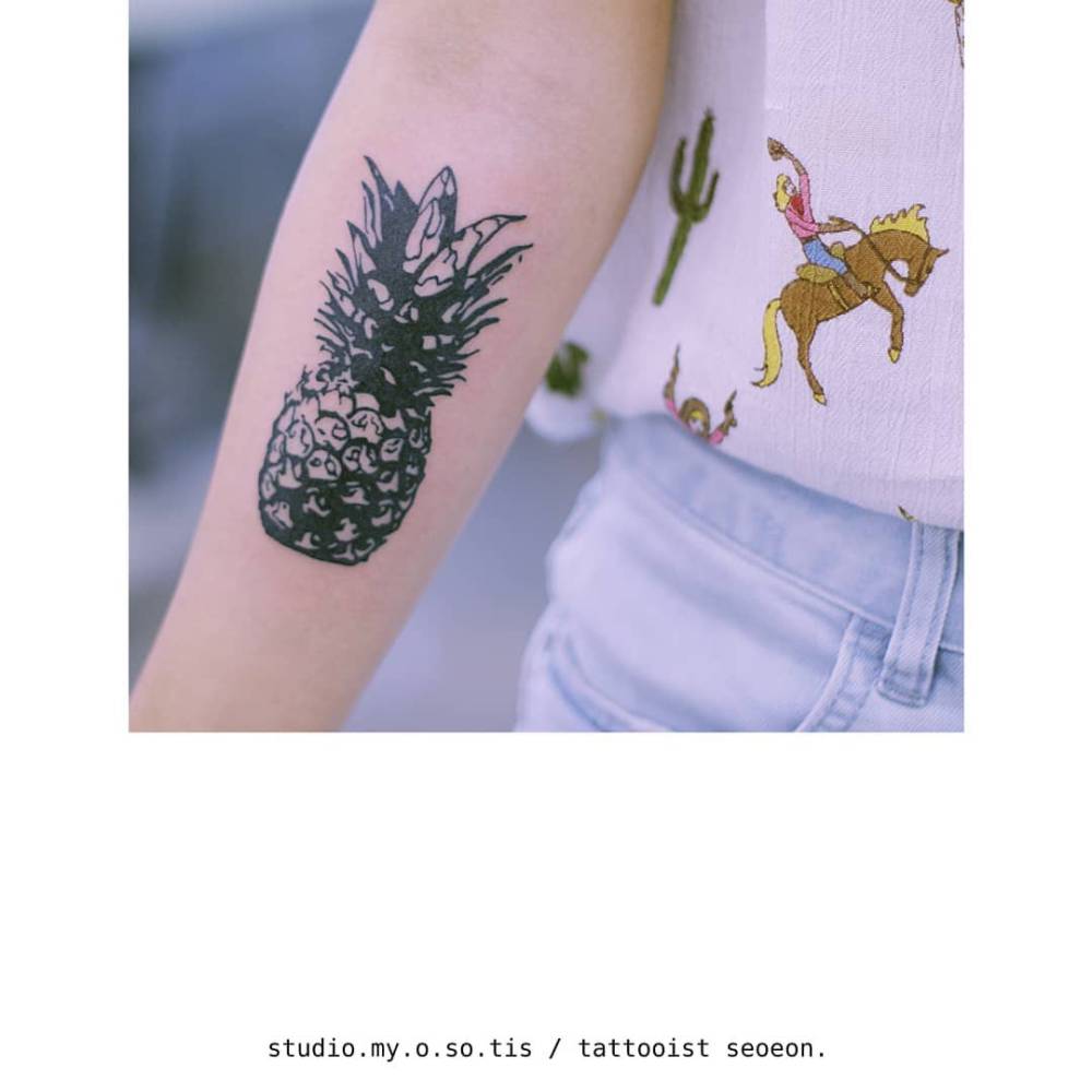 Blackwork style pineapple tattoo located on the inner forearm.