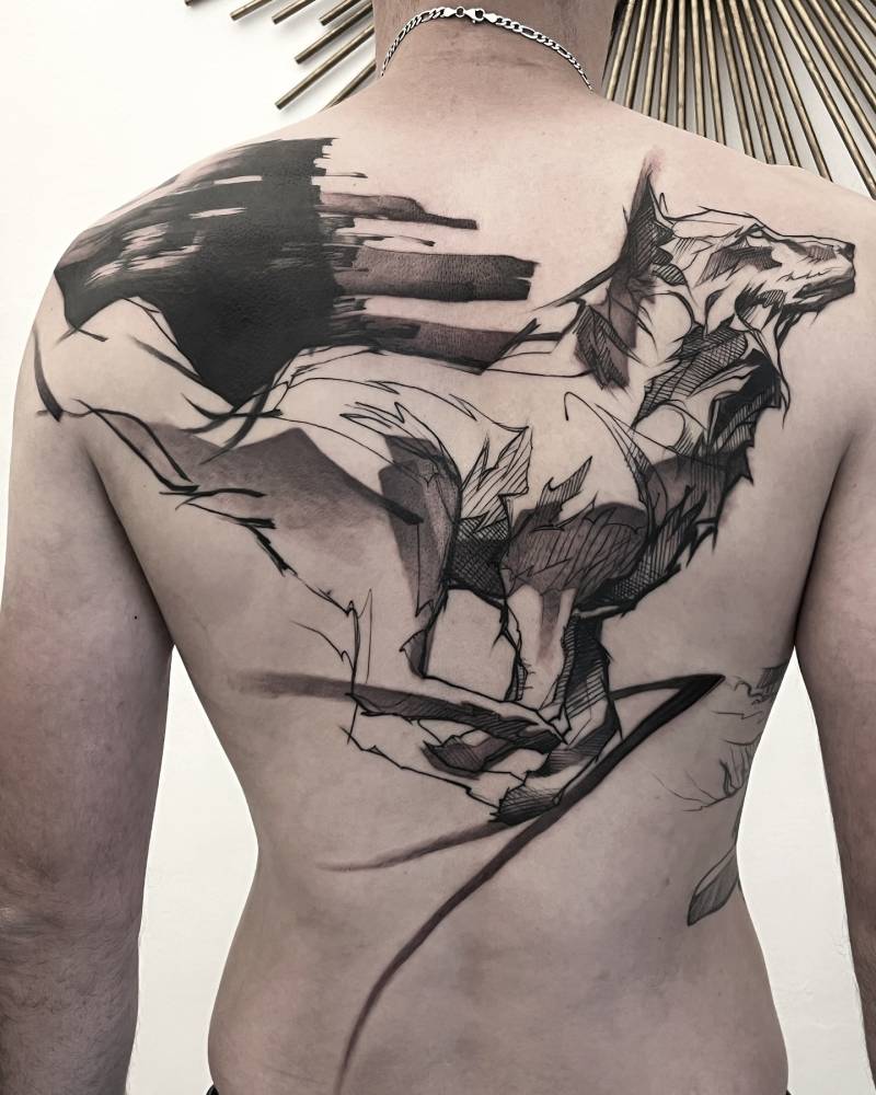 Wolf tattoo in sketch work style located on the back.
