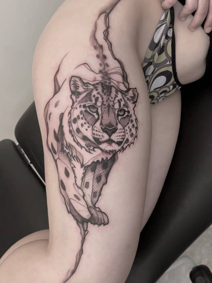 Leopard tattoo in sketch work style located on the thigh.