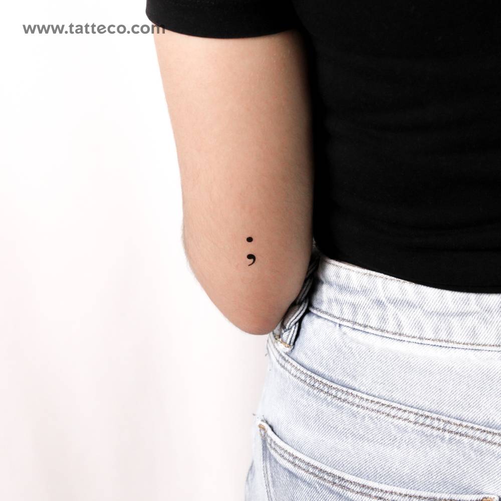 Minimalistic style semicolon temporary tattoo placed on the tricep.