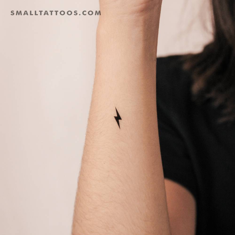 Small minimalistic lightning bolt temporary tattoo located on the wrist.