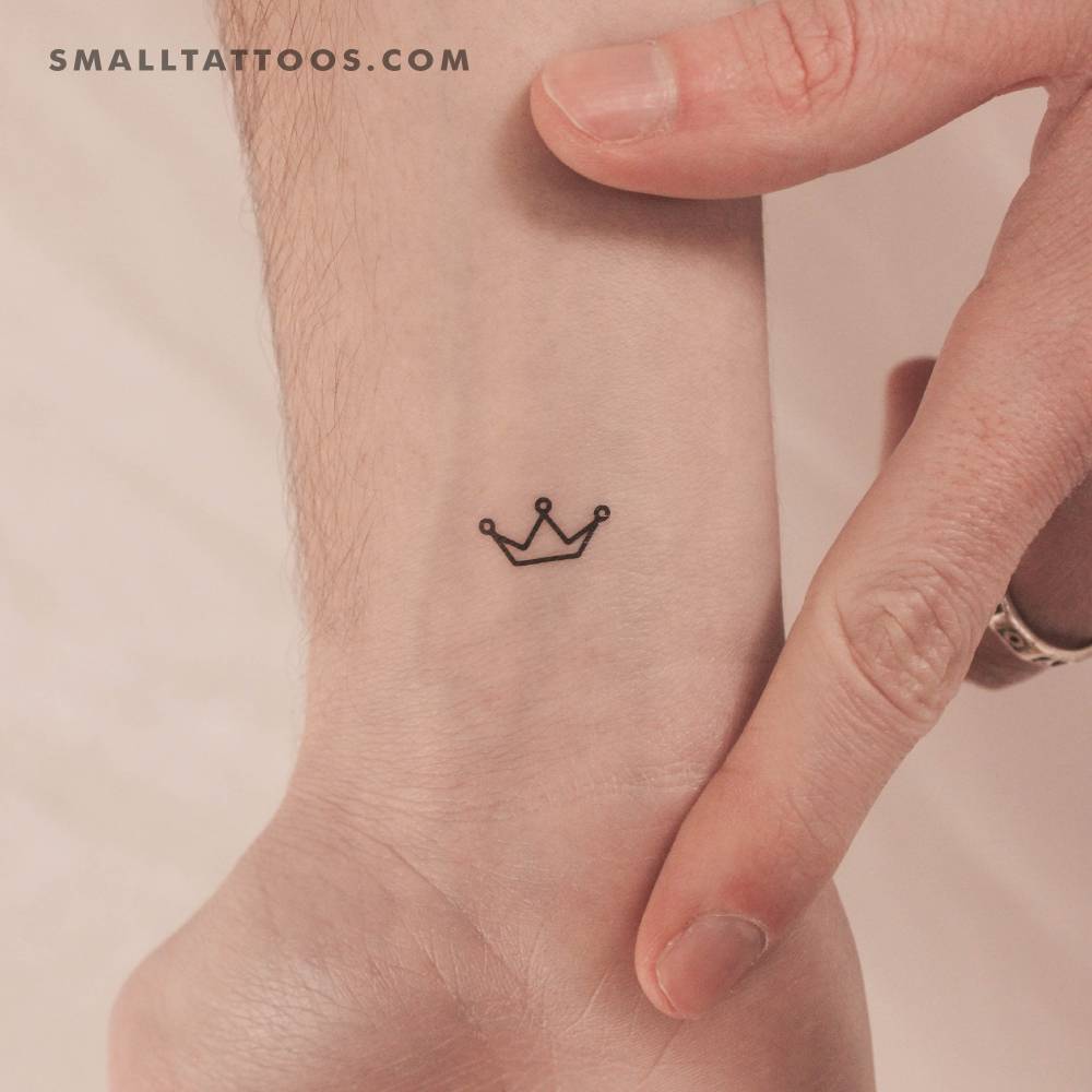 Minimalist crown temporary tattoo located on the wrist.