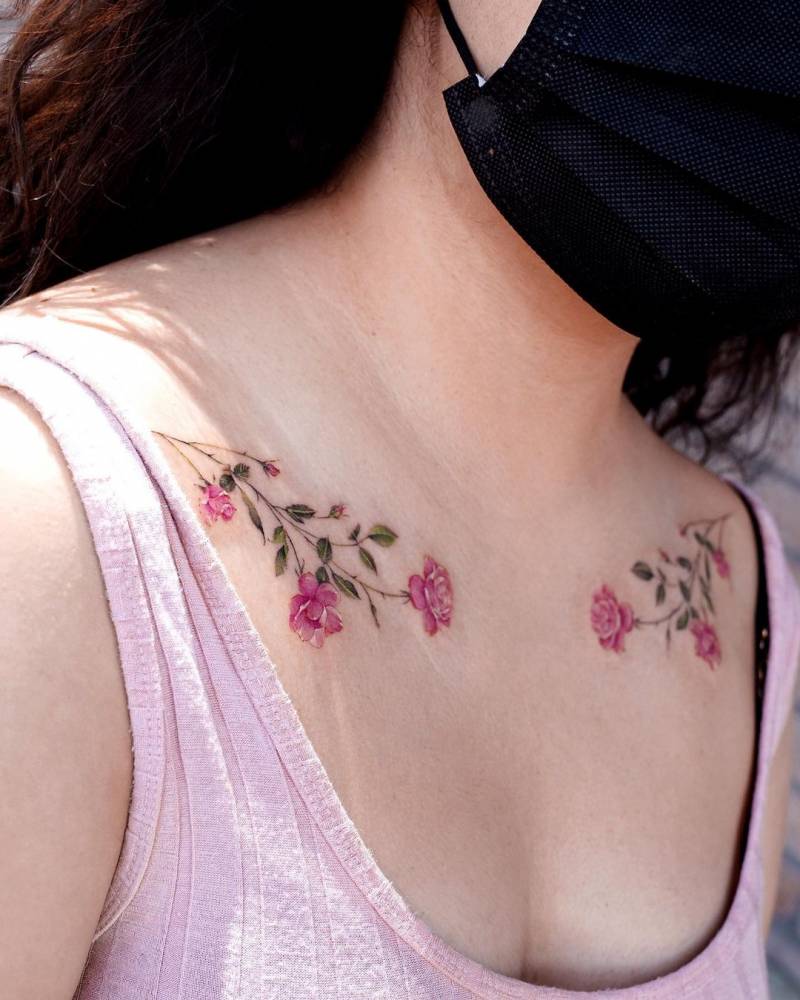Pink rose tattoo located on the collarbone, micro-realistic style.