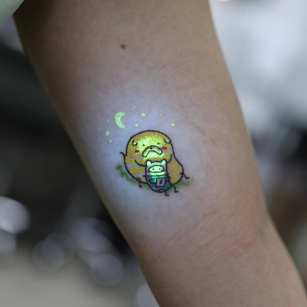 Jake and Finn tattoo in cartoon style placed on the inner arm.