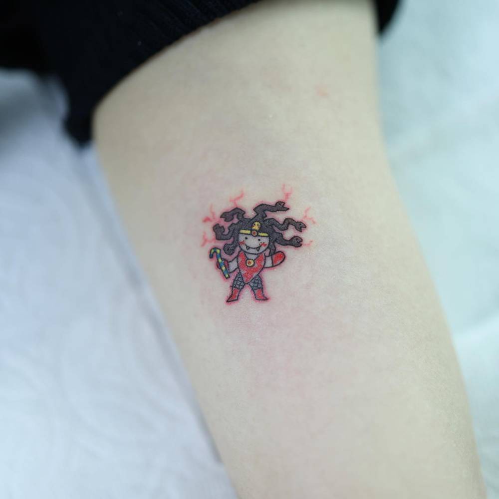 Little Medusa tattoo in cartoon style located on the inner arm.