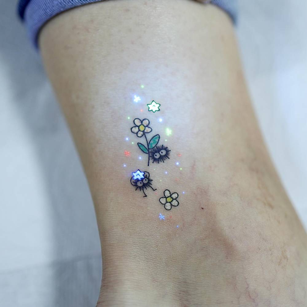 Cartoon style Soot Sprites tattoo located on the ankle.
