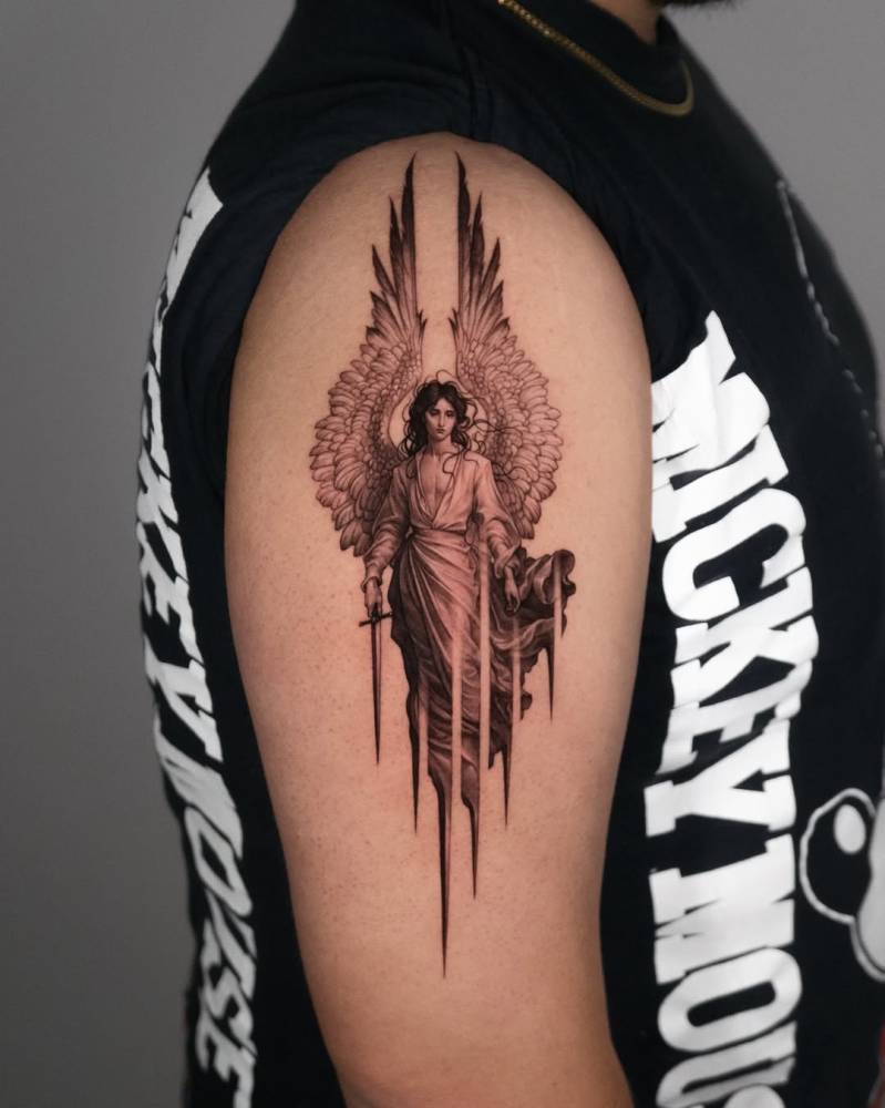 Micro-realistic style guardian angel tattoo located on the upper arm.