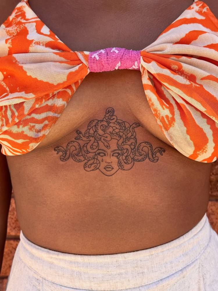 Medusa portrait tattoo in cartoon style located on the stomach.