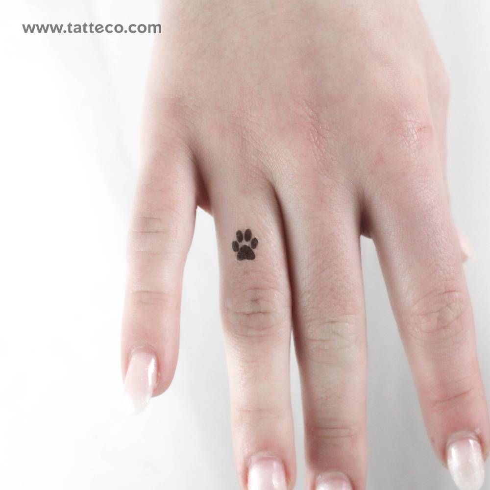 Small minimalistic paw print temporary tattoo placed on the finger.