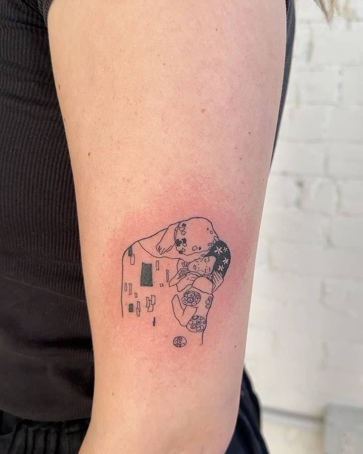 Klimt's 'The Kiss' tattoo located on the upper arm.