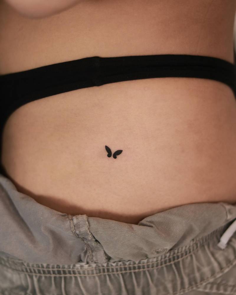 Minimalistic style butterfly tattoo located on the hip.