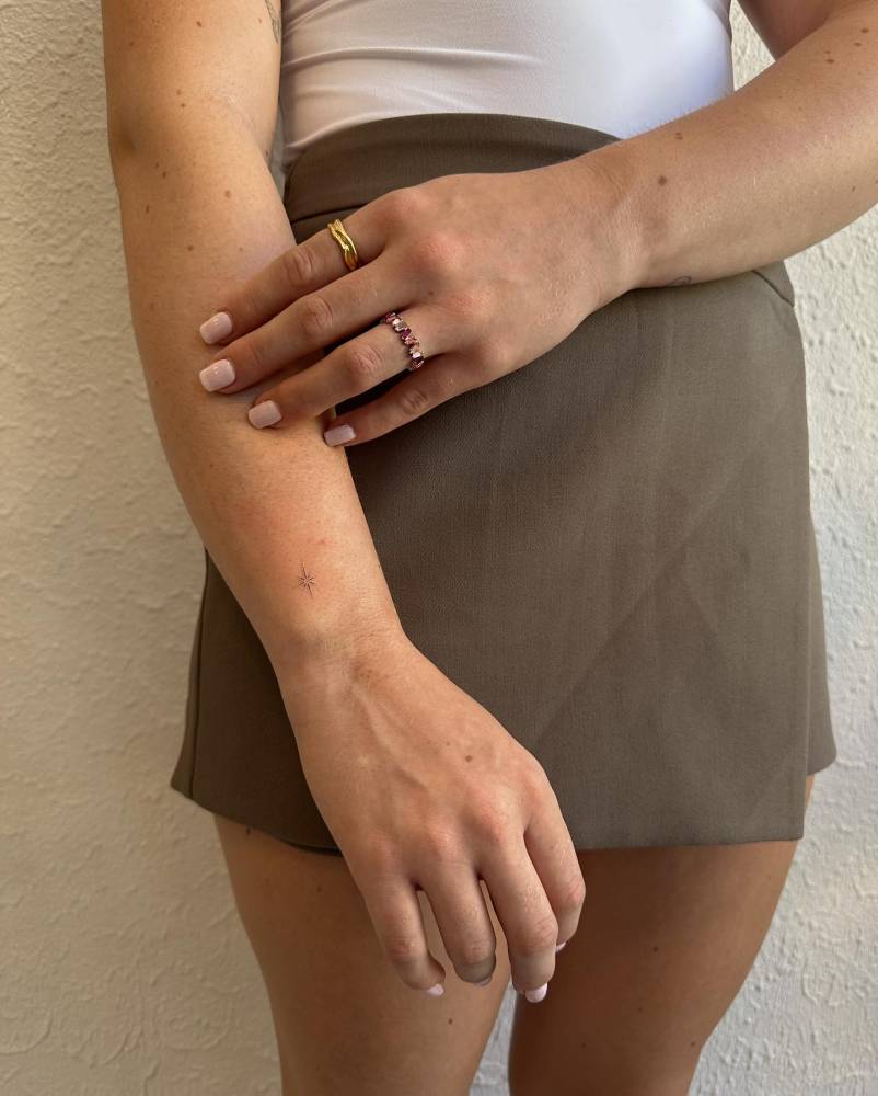 Cute little star tattoo placed on the wrist, minimalistic style.