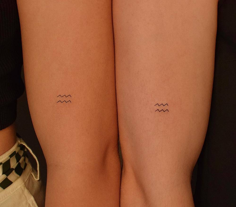 Matching Aquarius zodiac symbol tattoo for couple.