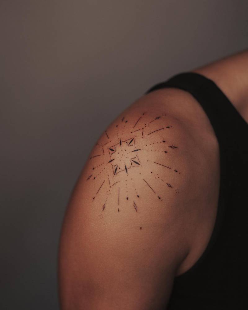 Fine line style ornamental tattoo located on the shoulder.