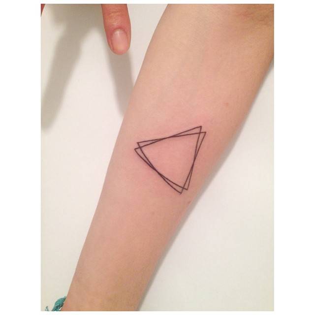 Geometric style triangles tattoo located on the inner forearm.