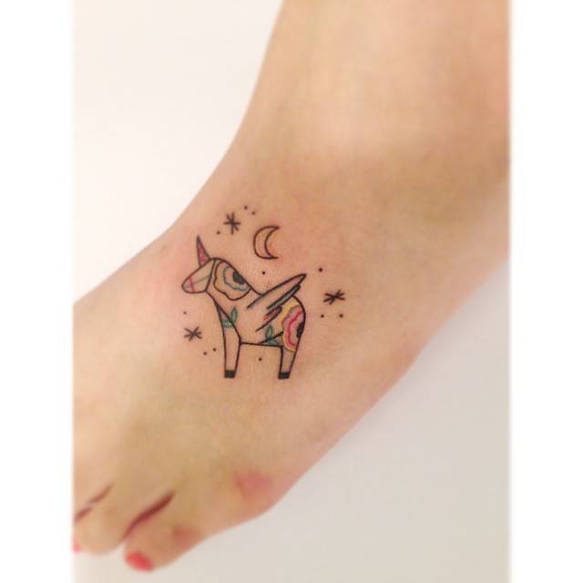 Abstract unicorn tattoo located on the foot.