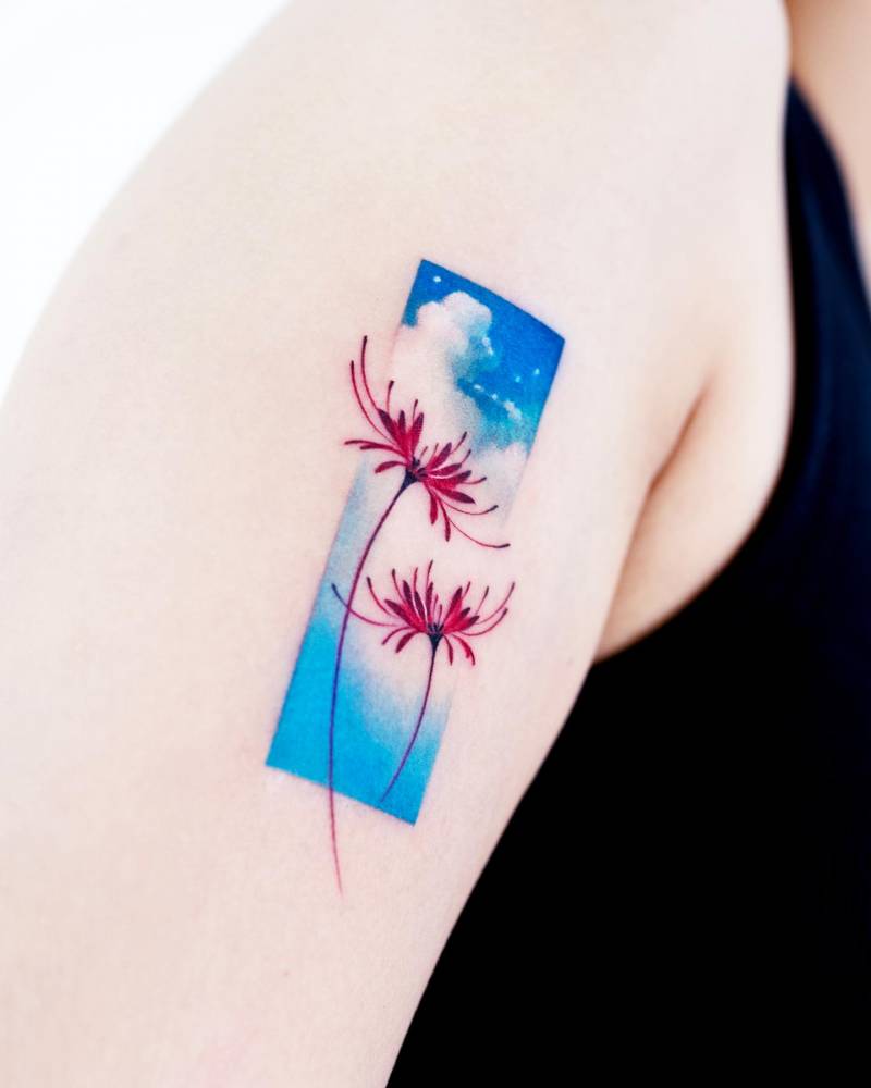 Red spider lily and cloud tattoo located on the upper arm.