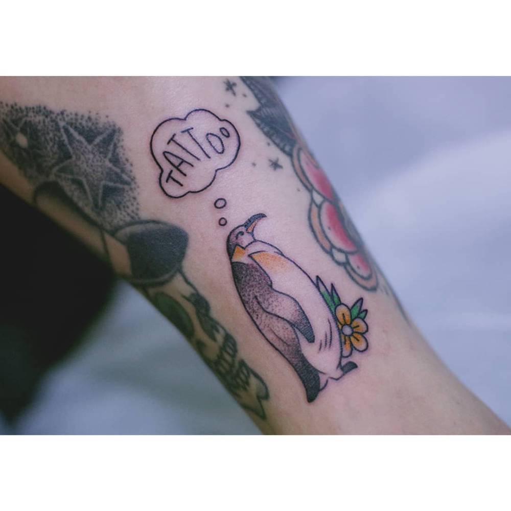 Penguin tattoo in illustrative style located on the inner forearm.