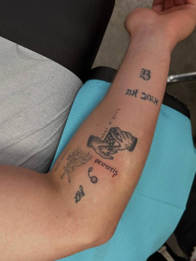 Greek word gap filler tattoo located on the inner forearm.