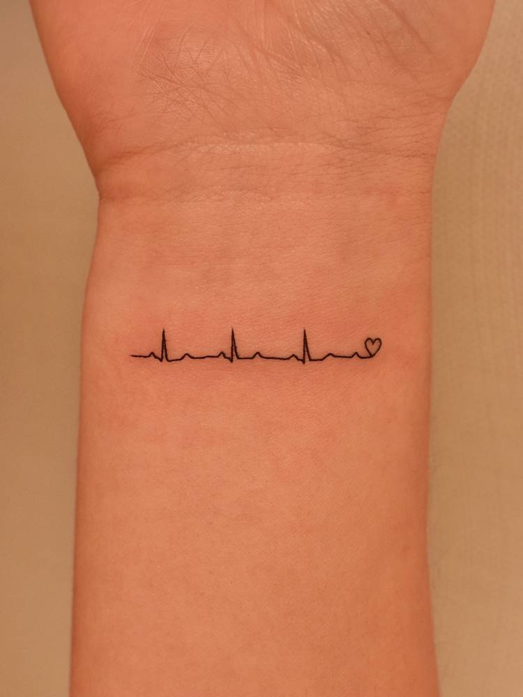 Heartbeat tattoo in minimalistic style placed on the wrist.