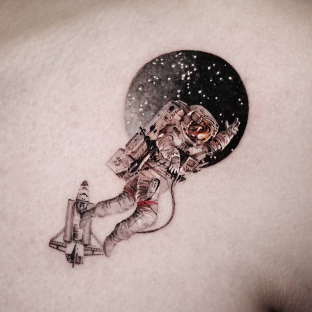 Astronaut tattoo in micro-realistic style placed on the shoulder.