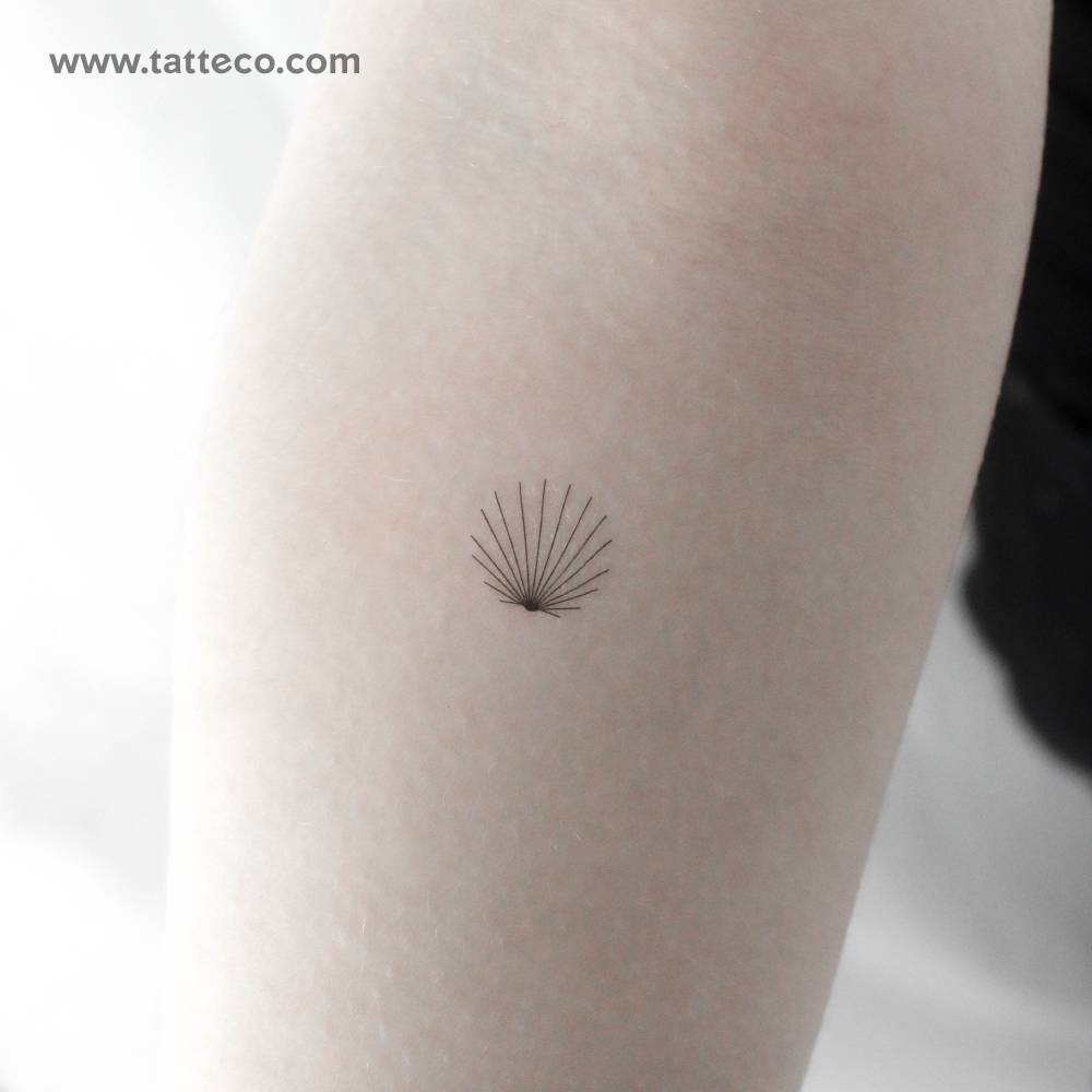 Tiny minimalist scallop shell temporary tattoo located on the inner forearm.