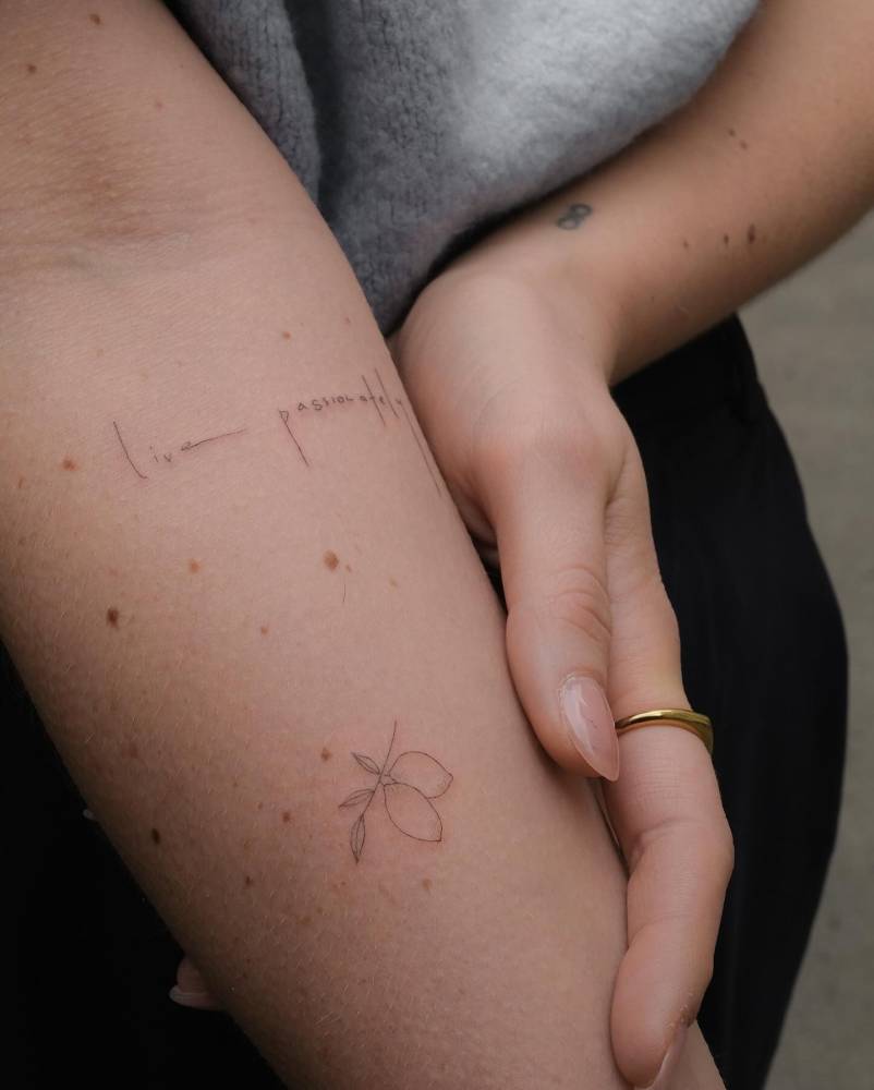 "Live passionately" and lemons tattooed on the inner forearm.