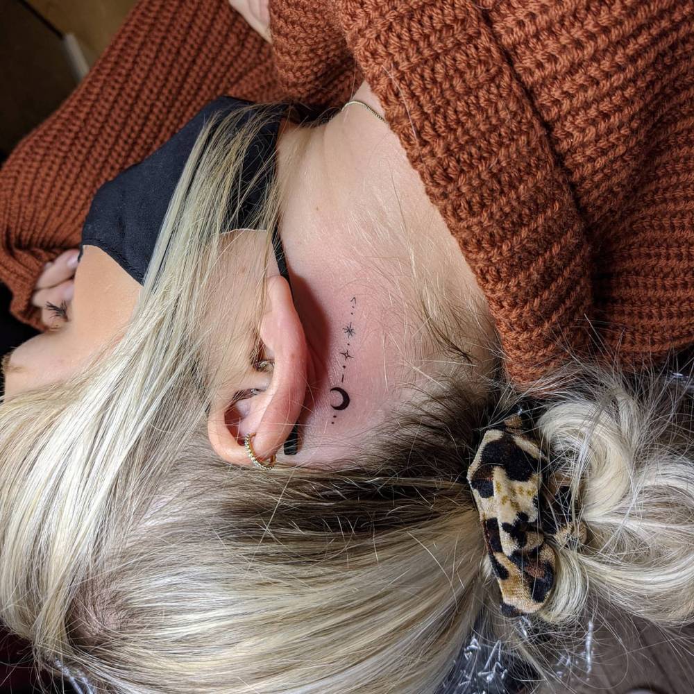 Behind the ear ornamental arrow tattoo.