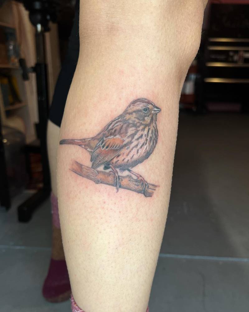 Illustrative style sparrow tattoo located on the calf.
