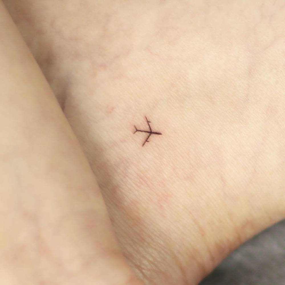 Minimalistic style airplane tattoo done on the ankle.
