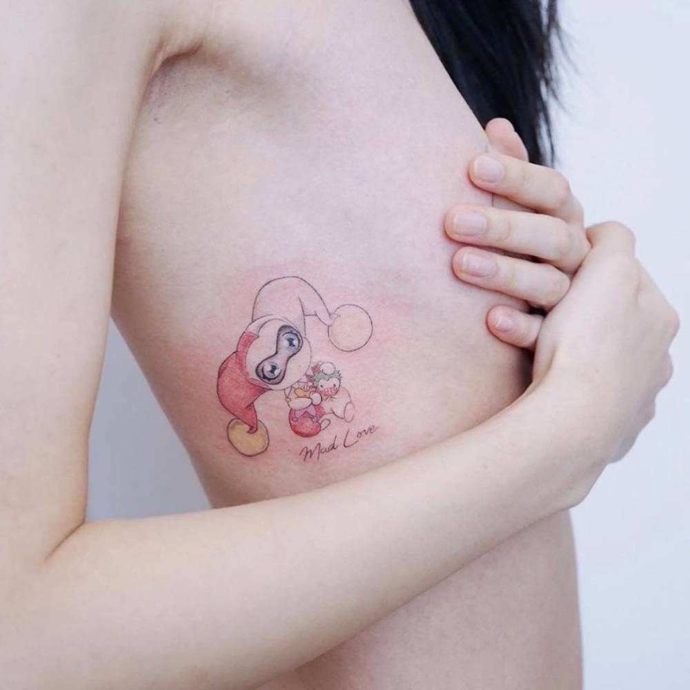 Watercolor Harley Quinn tattoo on the rib.