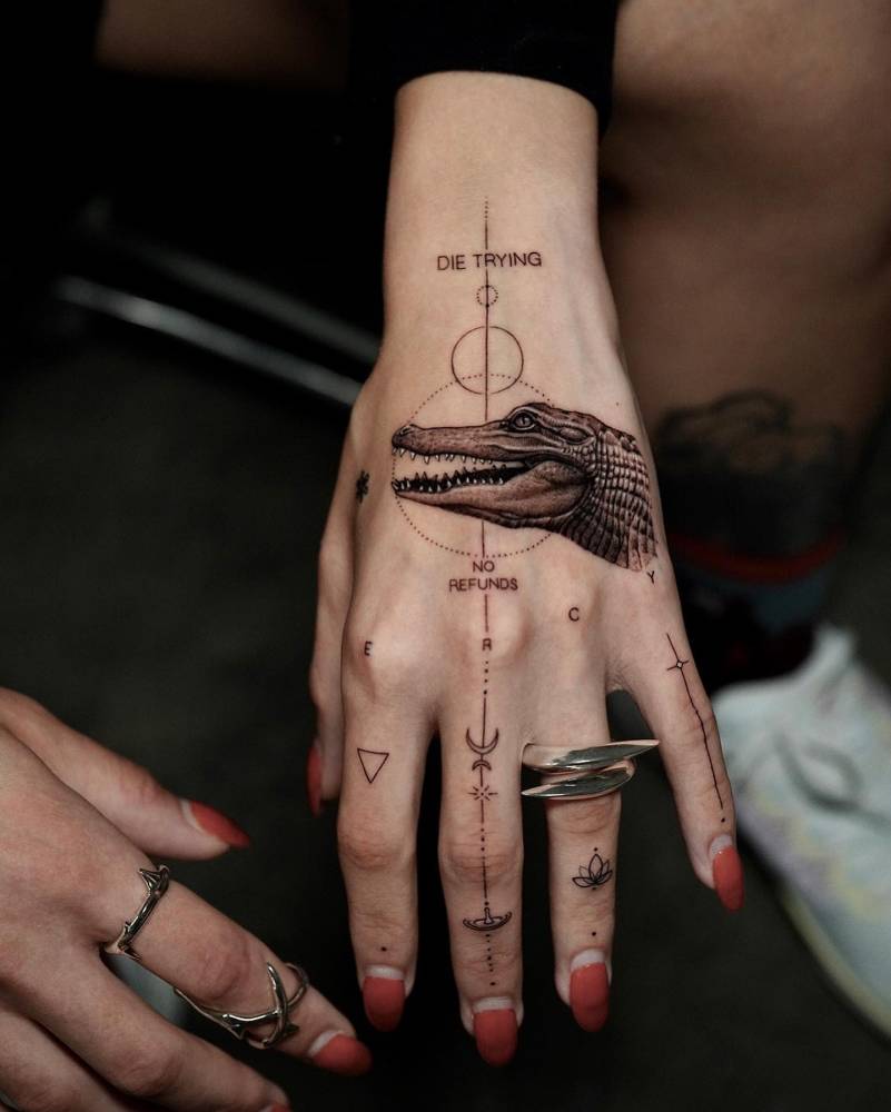 Micro-realistic style crocodile portrait tattoo located on the hand.