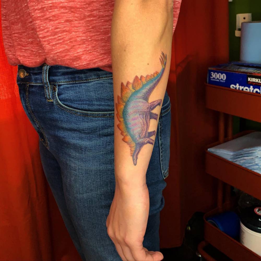 Realistic Stegosaurus tattoo located on the forearm.