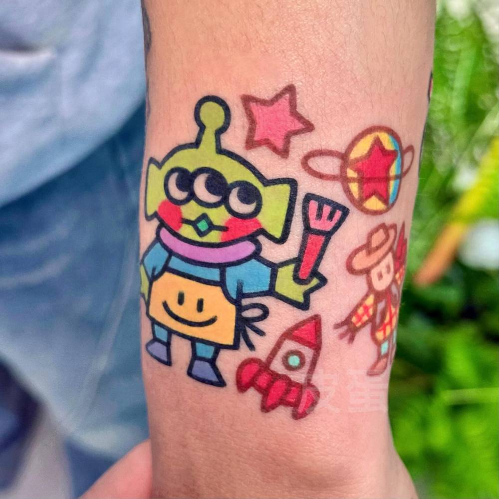 Toy Story Alien tattoo located on the wrist done in cartoon style.