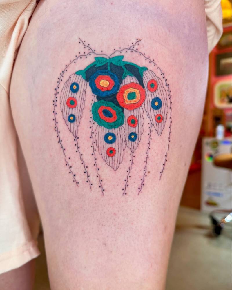 Floral design in illustrative style tattooed on the thigh.