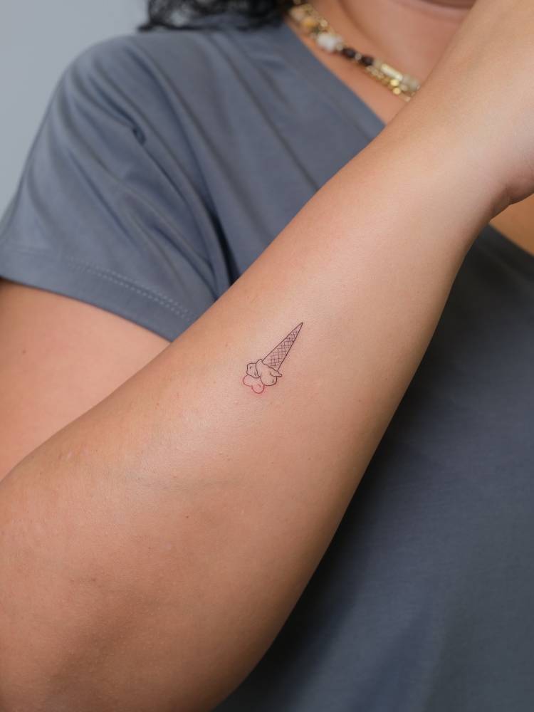 Love ice cream tattooed on the wrist, fine line style.