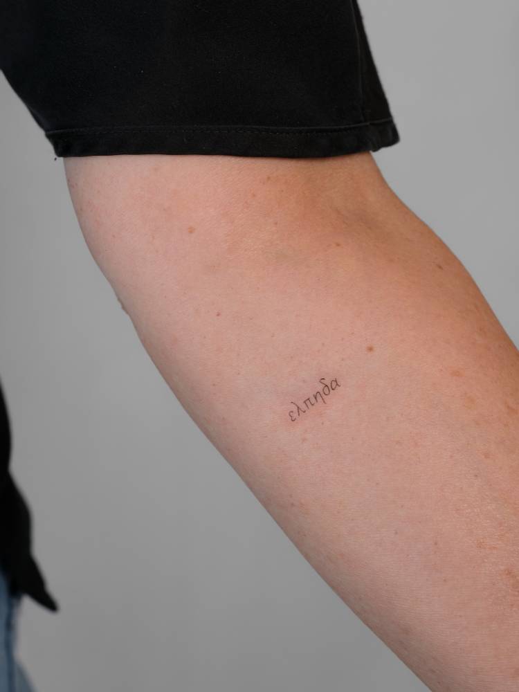 Greek word tattoo located on the inner forearm.