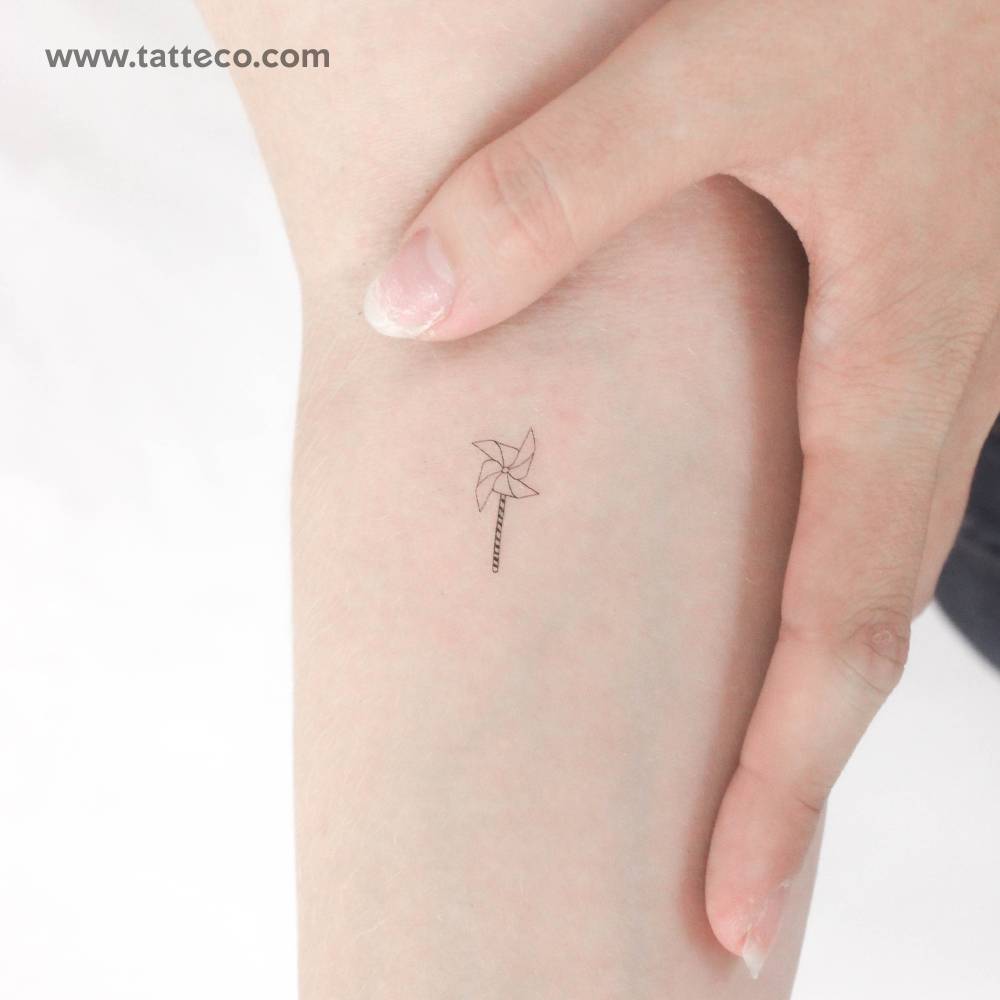 Fine line style little pinwheel temporary tattoo located on the inner forearm.